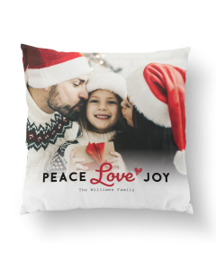 Christmas Peace Love Joy pillow with custom family photo of parents kissing a smiling child, featuring soft fabric and festive red lettering.